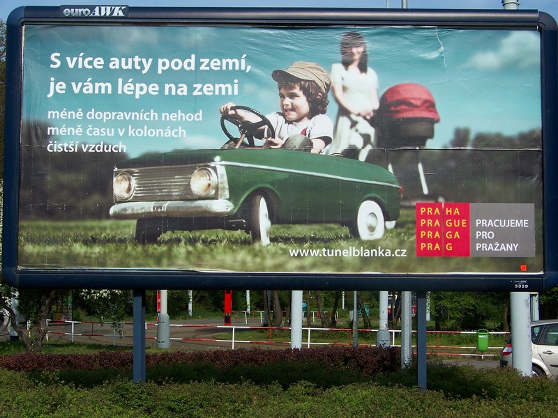 Ilustrace chlapaček sedí ve šlapacím autíčku a jezdí v parku...